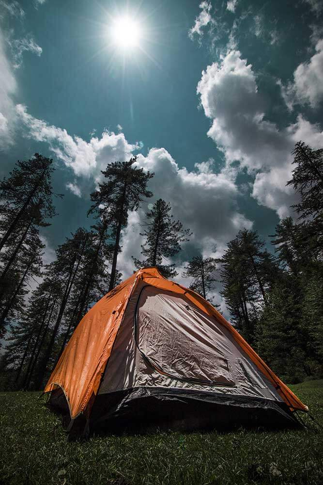 tent on field with blue sky and sun